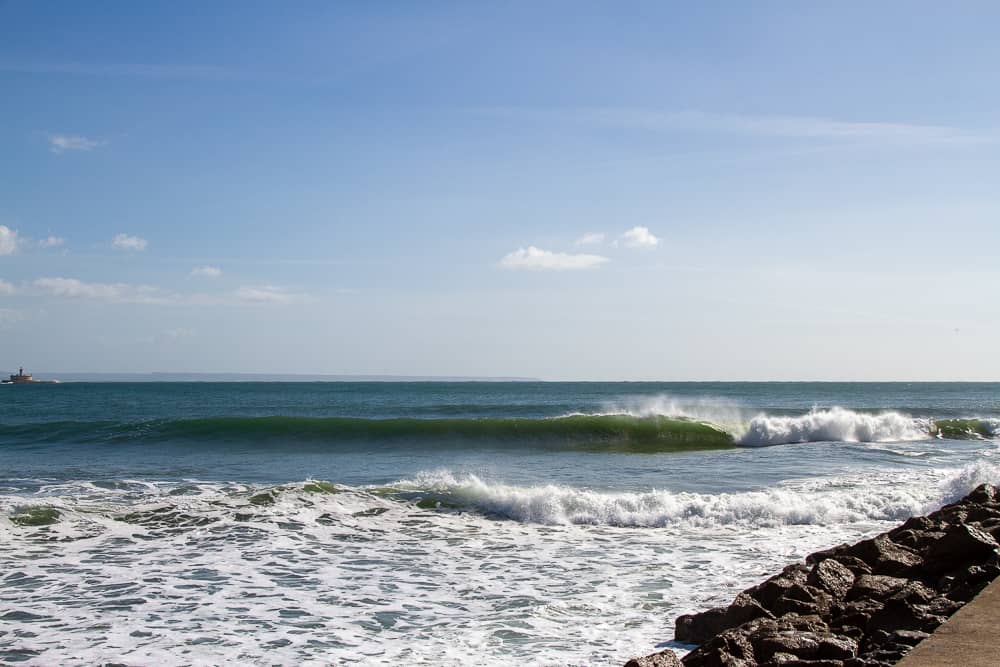 Wave breaking at Inatel reef with the Fort of São Lourenço do Bugio in the background