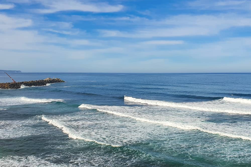 Waves breaking at Praia do Norte with the harbours jetty on the background